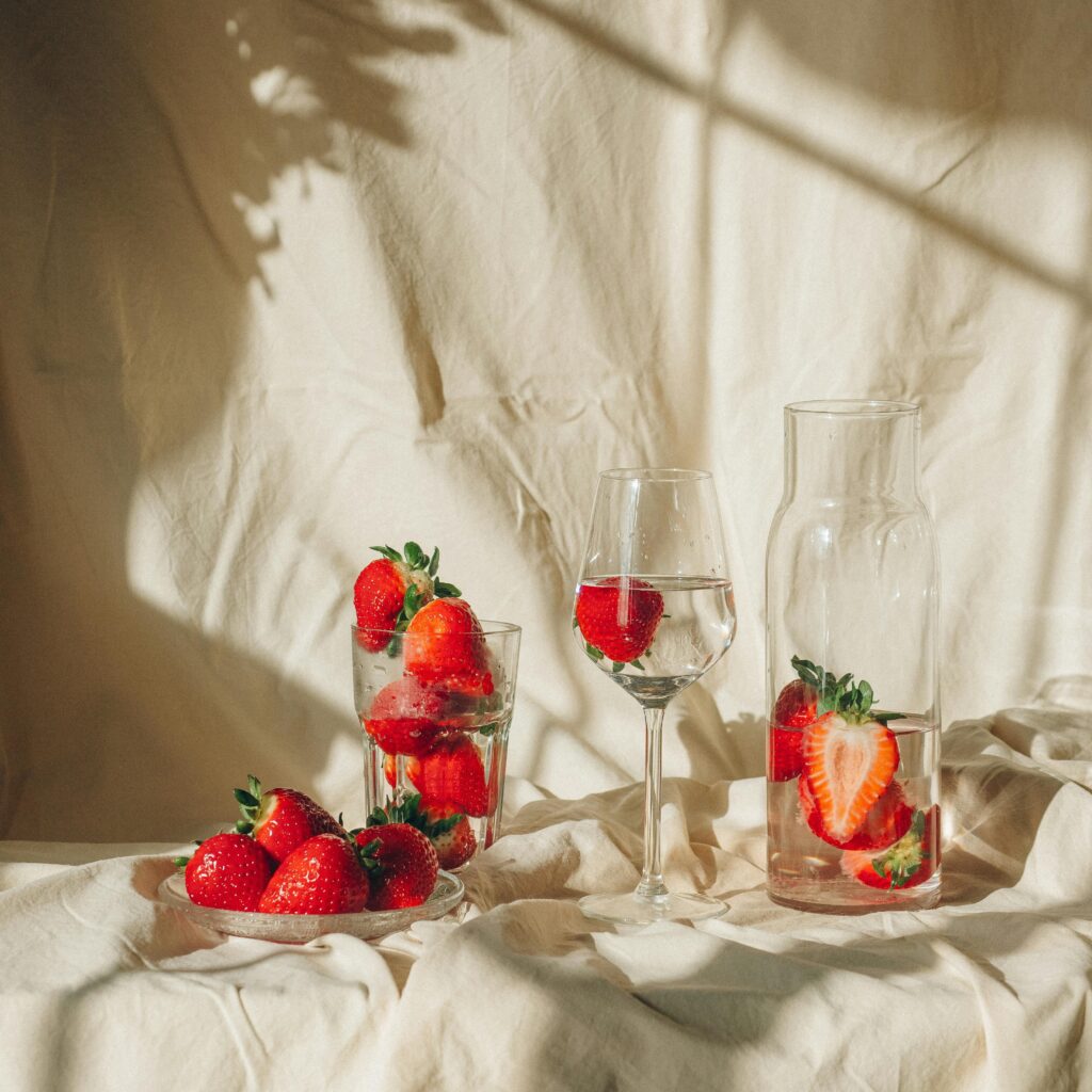 pexels-photo-7184344-7184344 Beautiful still life of strawberries in glasses and carafe with natural light and shadows.
